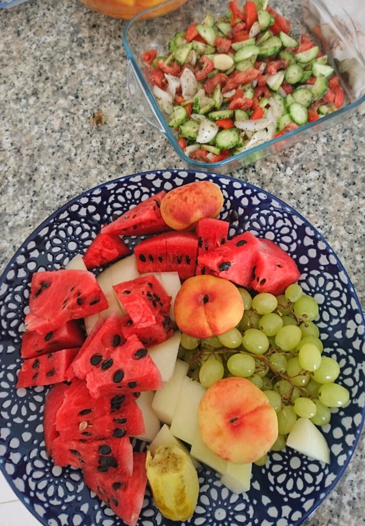 Obstteller mit Melone, Pfirsich und Trauben