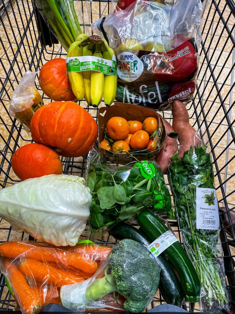 Ein Einkaufswagen voller Obst und Gemüse.