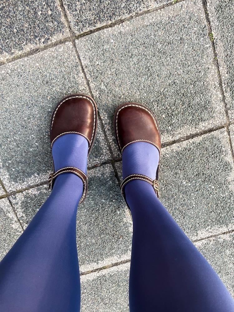 Füße in braunen Schuhen und blauen Strümpfen.