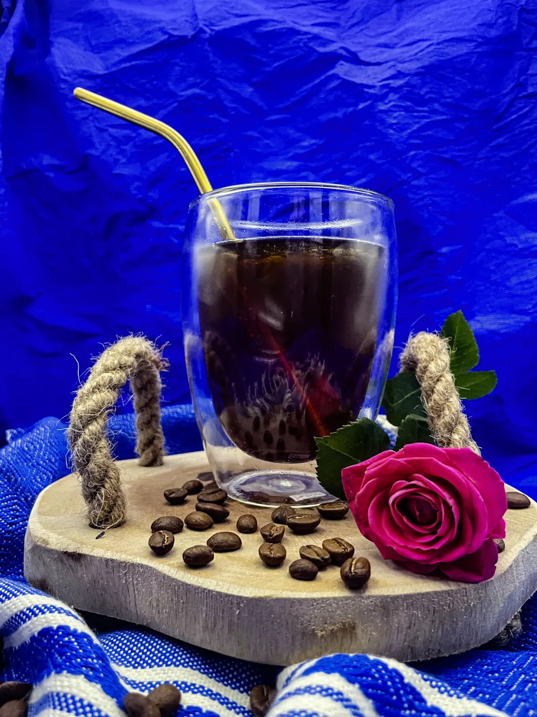 Cold Brew auf Tablett mit Kaffeebohnen und einer Rose.